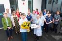 Jane Morgan (with flowers) is surrounded by colleagues as she celebrates 50 years of nursing.