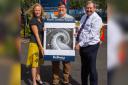 Gordon Calder (centre) holding his winning entry with Bellway North London sales manager Zoe Dobbs and sales advisor Mark Young at the development