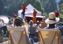 View from behind two visitors seated in deckchairs as part of the audience at an Illyria Theatre Company production.