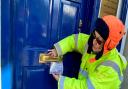 Trilby Roberts posts a flyer through Kemi Badenoch MP's office door in Saffron Walden