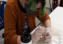 Jesse McCabe, a Laboratory Research Scientist at the Francis Crick Institute carefully examines a bone fragment in the research room at the Shirehill store.