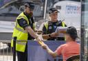 Officers check the details of a man who came to their attention at London Stansted bus station