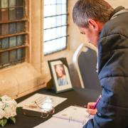 Members of the public sign the book of condolences, located in Saffron Walden Town Hall.