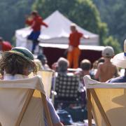 View from behind two visitors seated in deckchairs as part of the audience at an Illyria Theatre Company production.