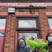 Mayor Heather Asker presents a surprise bouquet to Gita as she retires from East Street Store after more than 30 years and exactly 10 months after her husband and popular shop keeper Ram passed away