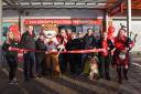 Corrie  bit through a string of sausages to officially open the new store