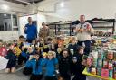 Members of the 1st Saffron Walden Scout Group, with Gillian Smith of Hope Community Food Hub, among all of the donations