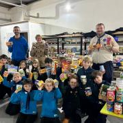 Members of the 1st Saffron Walden Scout Group, with Gillian Smith of Hope Community Food Hub, among all of the donations