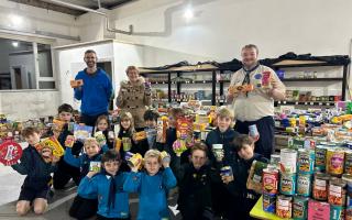 Members of the 1st Saffron Walden Scout Group, with Gillian Smith of Hope Community Food Hub, among all of the donations