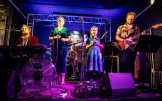 Rosie Porter on stage with Elliot Porter and musicians